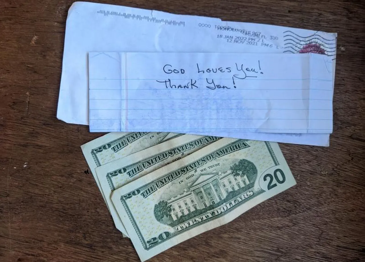 An opened envelope and a handwritten note that says: God loves You! Thank You!