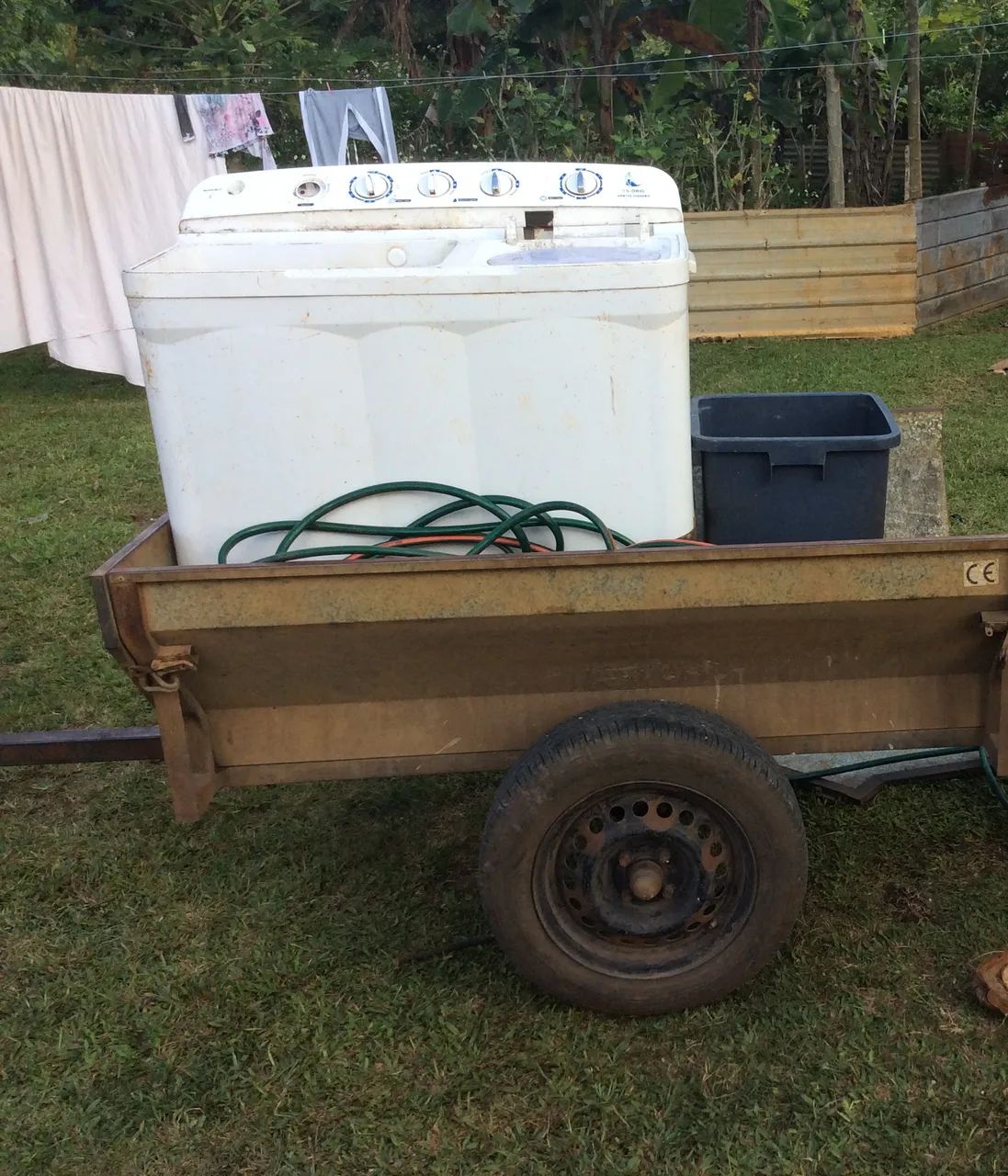 An old twin-tub washing machine and a garden hose on the trailer